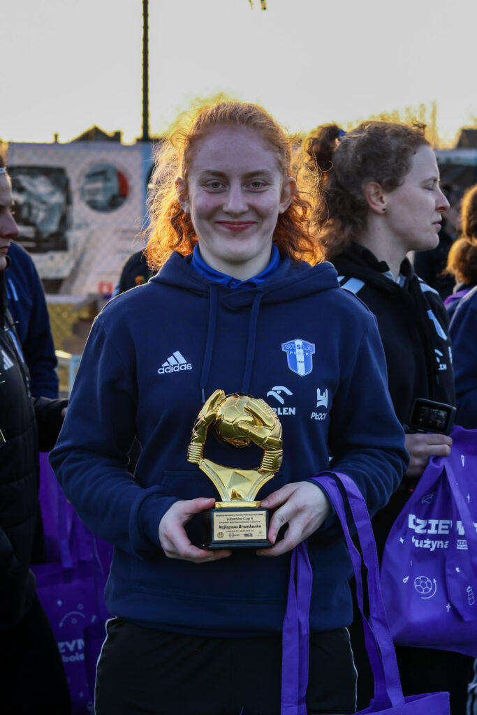 Młoda zawodniczka Nafciarki Wisły Płock w granatowej bluzie z logo klubu trzyma złoty puchar podczas Lubartów Cup 4.